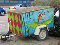 828650 Afbeelding van o.a. met een aapje en een krokodil beschilderd aanhangwagentje, geparkeerd in de Raamstraat te Utrecht.
